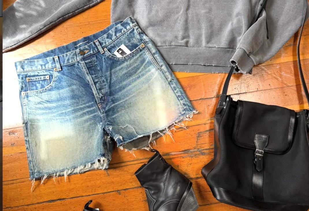 Flat-lay with vintage-wash denim shorts, sweatshirt and boots